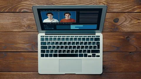 Editing faces using deep fake technology on a laptop in a home setting during Stock Photos