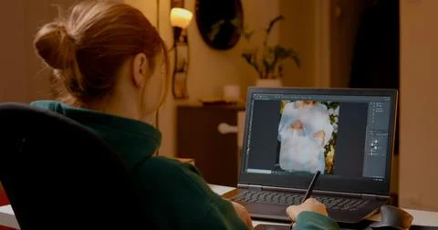 Editing images with graphics tablet in a cozy home studio setting at night Stock Photos
