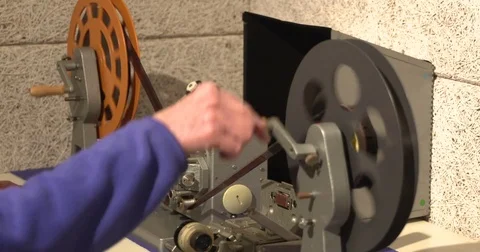 Editor at work, using a vertical film viewer, projecting film on a small screen 動画素材 75677031