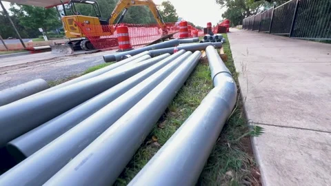 Editorial Construction Scene with CAT Excavator and PVC Pipes on Roadside 4 Stock Footage 310520319