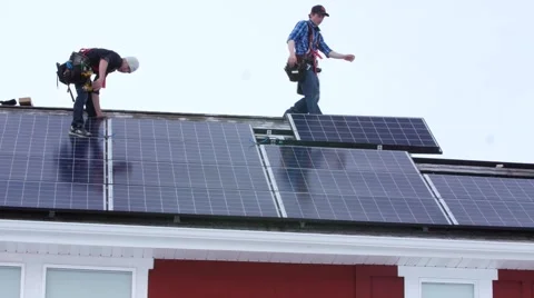 Editorial crew placing solar panels on the roof of house Stock Footage 58850426