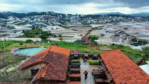 Editorial drone flight over red tile roofs toward Da Lat greenhouses 4K Vídeo Stock 341541852