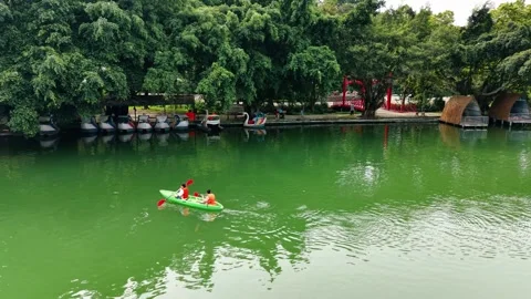 Editorial drone tracking past visitors rowing boat on blue lake in Ba Vi 4K 스톡 동영상 341551291