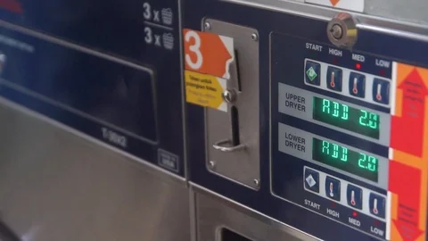 Editorial : Hand inserting coins into laundry machine. soft focus. Stock Footage 119187412