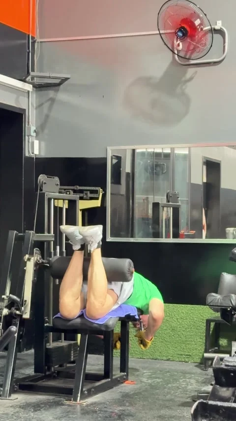 Editorial: Senior Man Exercising with Lying Leg Curl Machine at Gym Stock Footage 330742938