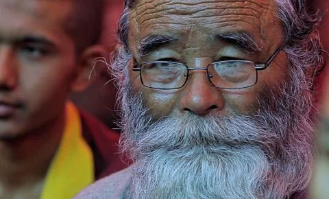 Editorial shot of an elderly Buddhist devotee with a long beard wearing glasses Stock Photos