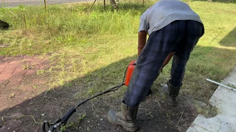 Editorial shot of worker using grass cutting machine Stock Footage 328486498