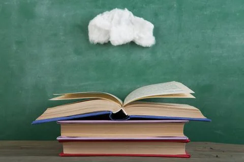 Education and reading creative concept - open under the cotton clouds book, i Stock Photos
