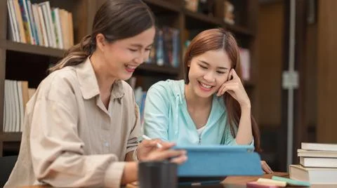 Education concept, Female tutor pointing math quiz on tablet and explaining m Stock Photos