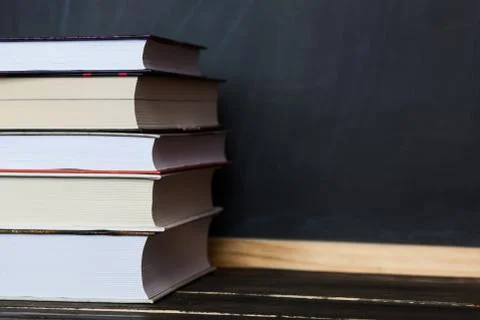 Education concept. Stack of books with chalkboard in background. Free place f Stock Photos