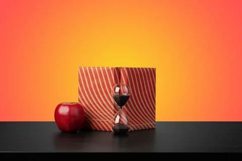 Education concept with stack of books on a table against colored background. Stock Photos