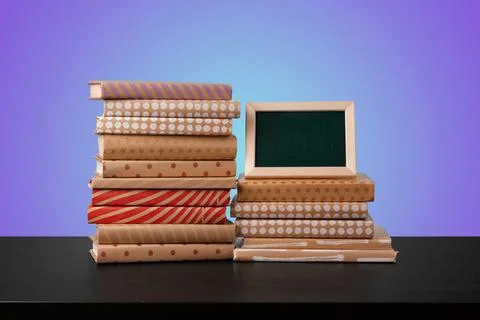Education concept with stack of books on a table against colored background. 写真素材