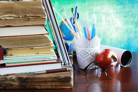 Education concept. A stack of textbooks and a book on the desk with glasses.. Stock Photos