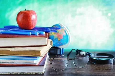 Education concept. A stack of textbooks and a book on the desk with glasses.. Stock Photos