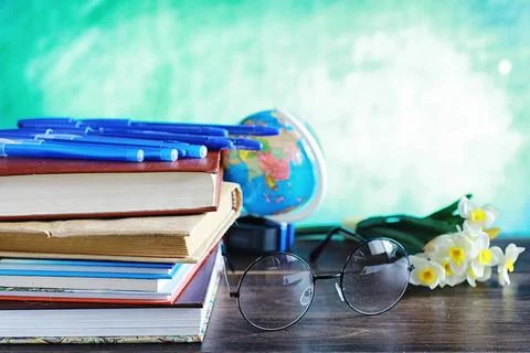 Education concept. A stack of textbooks and a book on the desk with glasses.. Stock Photos