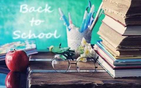 Education concept. A stack of textbooks and a book on the desk with glasses.. Stock Photos