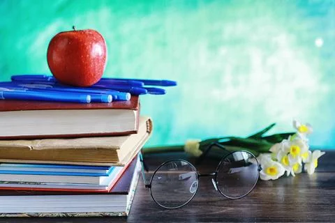 Education concept. A stack of textbooks and a book on the desk with glasses.. Stock Photos