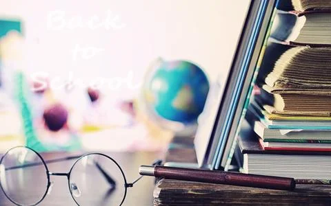 Education concept. A stack of textbooks and a book on the desk with glasses.. Stock Photos