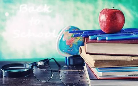 Education concept. A stack of textbooks and a book on the desk with glasses.. Stock Photos