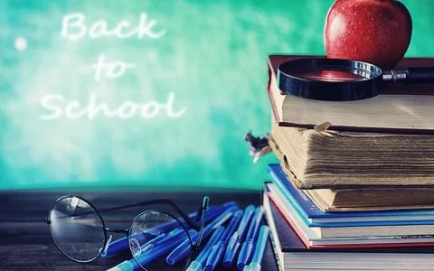 Education concept. A stack of textbooks and a book on the desk with glasses.. Stock Photos
