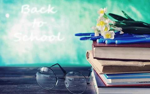 Education concept. A stack of textbooks and a book on the desk with glasses.. Stock Photos