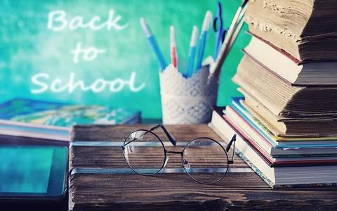 Education concept. A stack of textbooks and a book on the desk with glasses.. Stock Photos