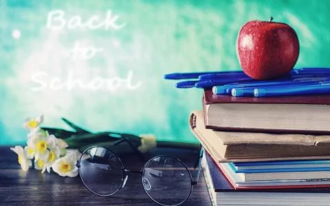Education concept. A stack of textbooks and a book on the desk with glasses.. Stock Photos