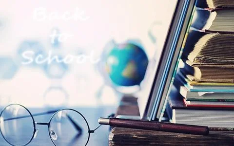 Education concept. A stack of textbooks and a book on the desk with glasses.. Stock Photos