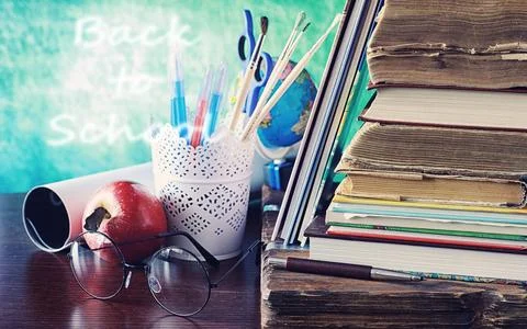 Education concept. A stack of textbooks and a book on the desk with glasses.. Stock Photos