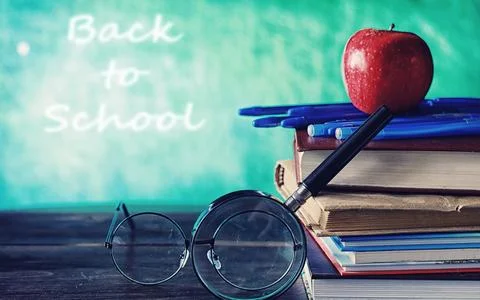 Education concept. A stack of textbooks and a book on the desk with glasses.. Stock Photos