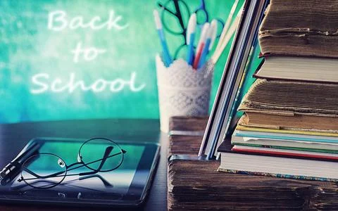 Education concept. A stack of textbooks and a book on the desk with glasses.. Stock Photos