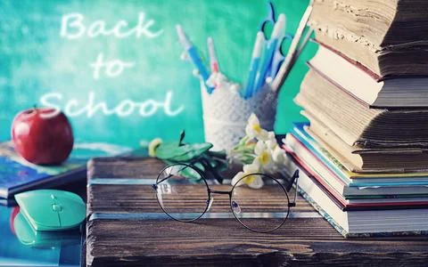 Education concept. A stack of textbooks and a book on the desk with glasses.. Stock Photos