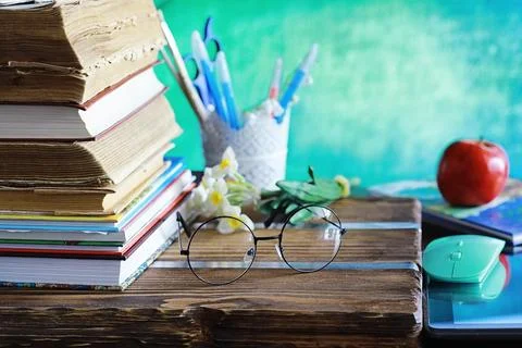 Education concept. A stack of textbooks and a book on the desk with glasses.. Stock Photos