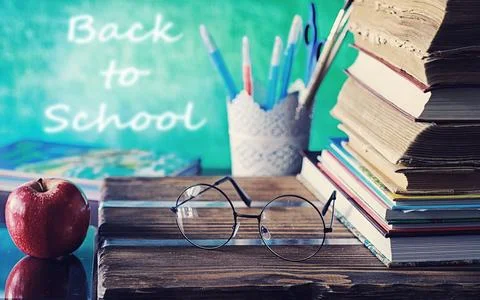 Education concept. A stack of textbooks and a book on the desk with glasses.. Stock Photos