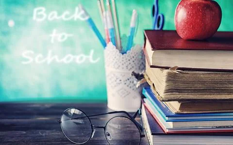 Education concept. A stack of textbooks and a book on the desk with glasses.. Stock Photos