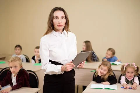 Education, elementary school, learning and people concept. Teacher and students Stock Photos