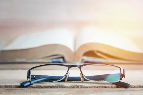 Education, improve and knowledge concept, glasses and book on wood table . Fotos de archivo
