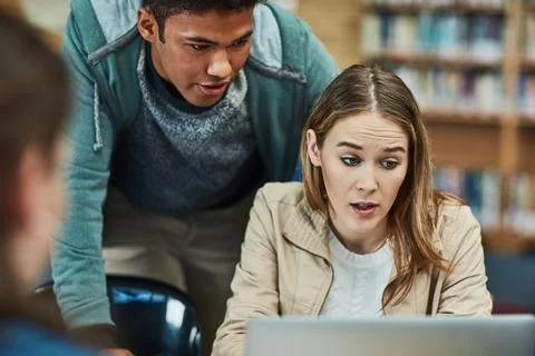 Education, laptop and problem solving with students in library of university for Stock Photos