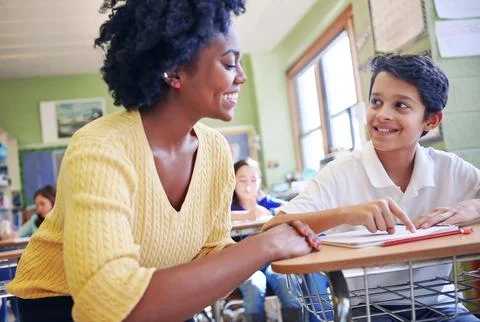 Education, learning and teacher help student with assignment in elementary Stock Photos