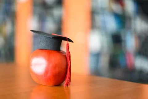 Education learning concept - Graduation cap on apple on the table with book.. Stock Photos