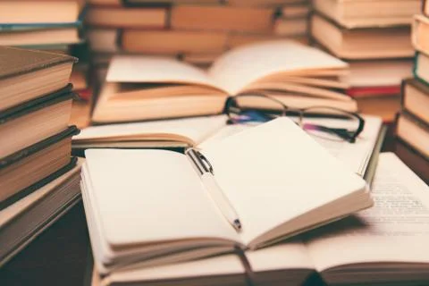 Education learning concept with open book and notebook on the table. Stack pi Stock Photos