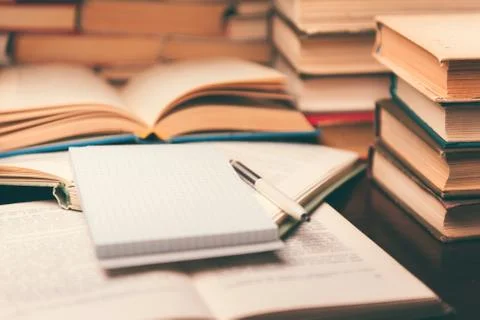 Education learning concept with open book and notebook on the table. Stack pi Stock Photos