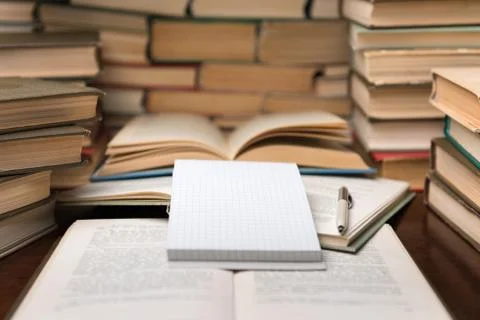 Education learning concept with open book and notebook on the table. Stack pi Stock Photos