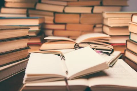 Education learning concept with open book and notebook on the table. Stack pi Stock Photos