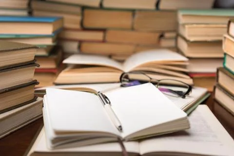 Education learning concept with open book and notebook on the table. Stack pi Stock Photos