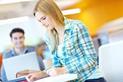 Education, problem solving and reading with student woman in library at college Foto stock