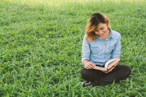 Education woman.Young beautiful woman reading a book in the park. Stock Photos