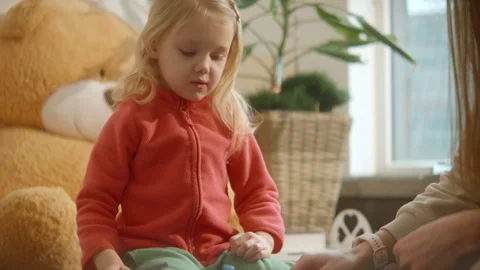 Educational games concept, cute child plays board game with mom, using hammer. Stock Footage 257107378