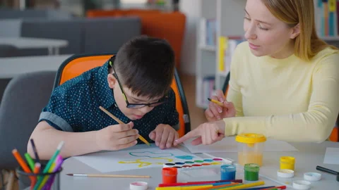 Educational psychologist develops skills of a boy with Down Syndrome by teaching Video stock 242305018