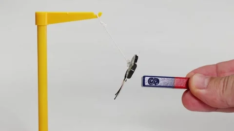 Educational science experiment showing magnetic force pulling toy butterfly.. Stock Footage 332719780